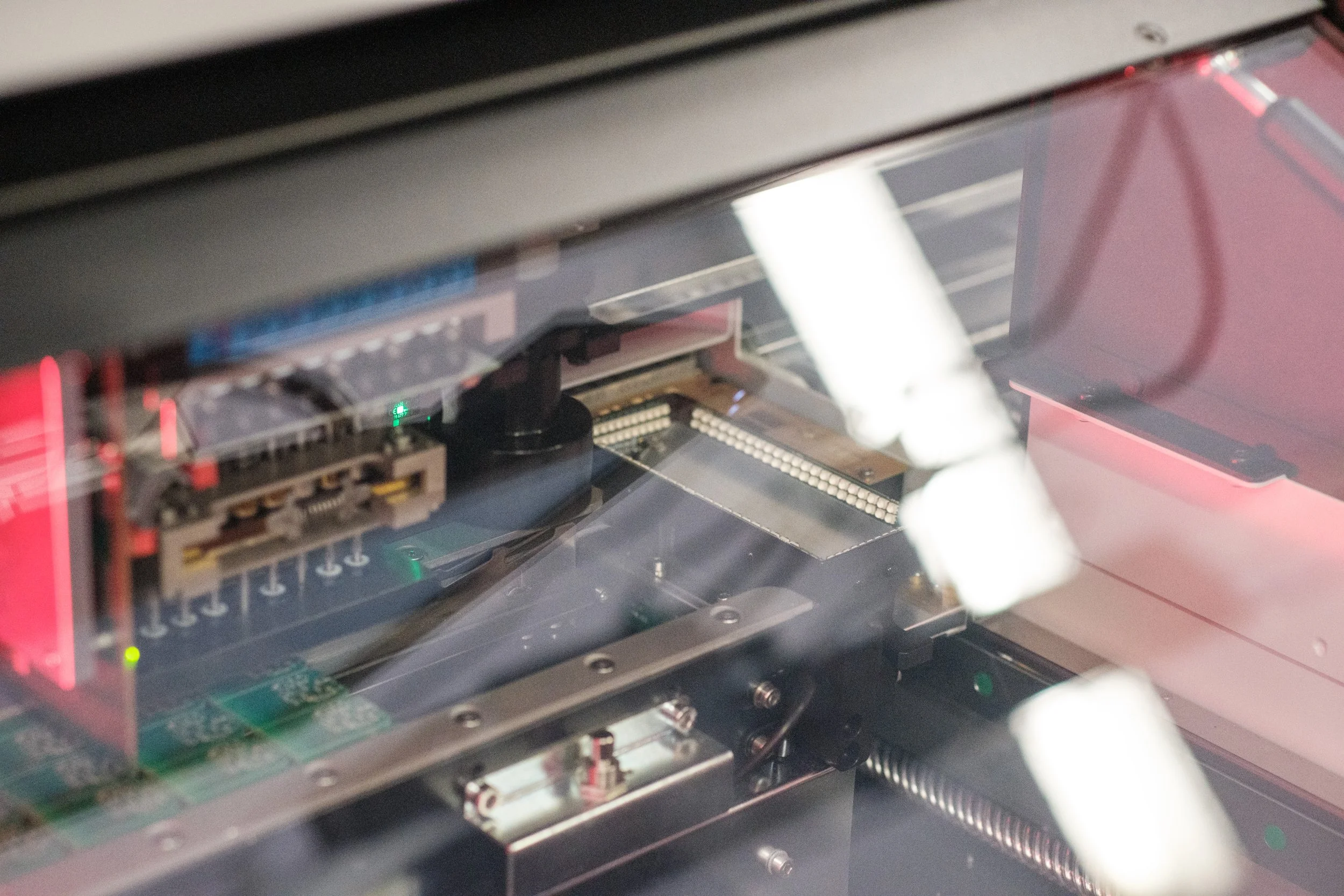 Innenseite eines modernen Computers mit sichtbaren Leiterplatten, Kabeln und elektronischen Komponenten, durch ein glasartiges Gehäuse betrachtet.