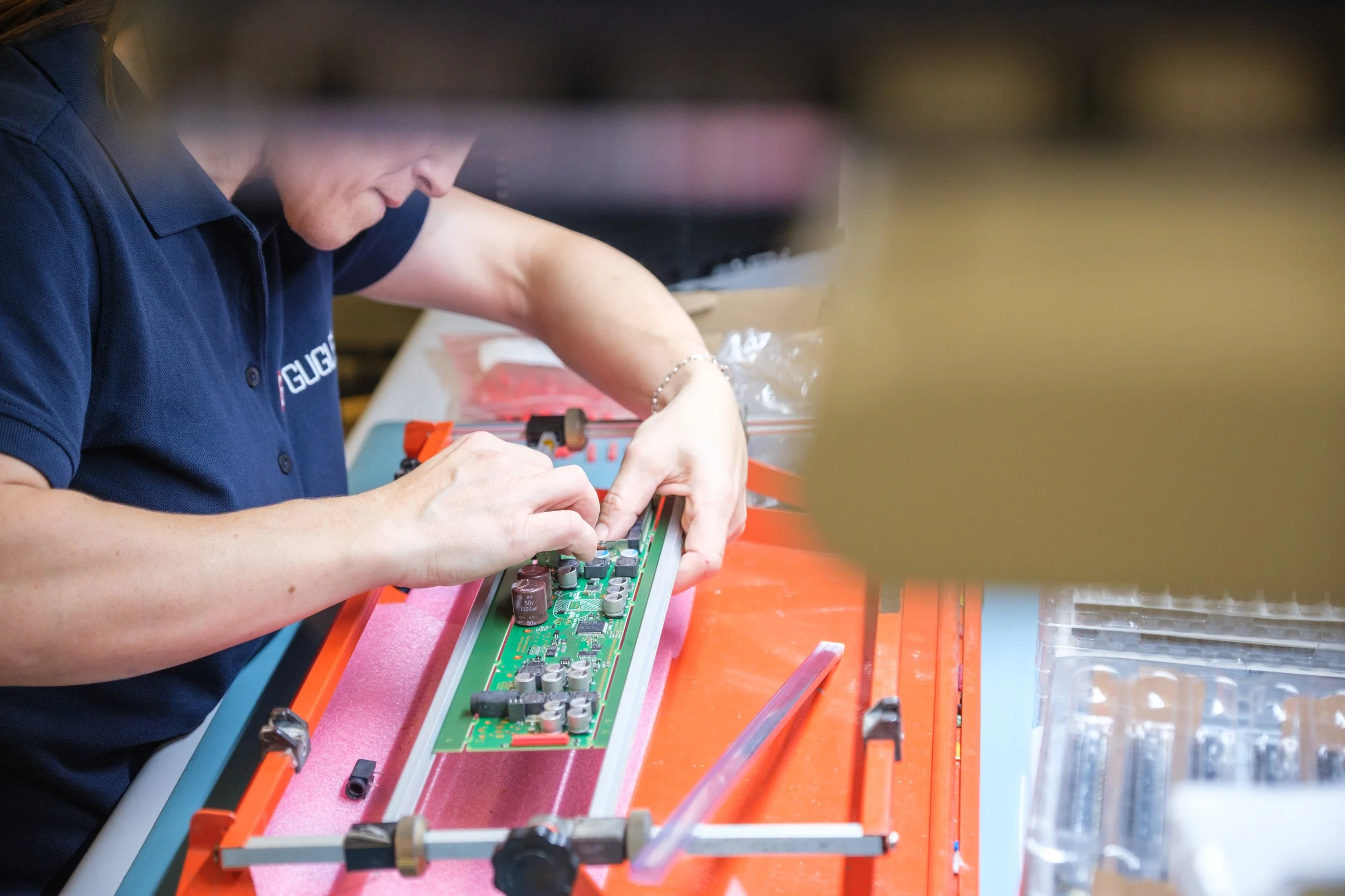 Mensch arbeitet an einer Leiterplatte in einem Elektroniklabor.